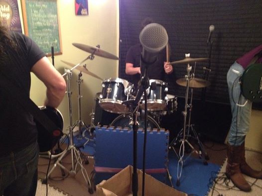 Kevin and Kerry in rehearsal. Kevin on the left from behind playing bass and Kerry in the center playing drums